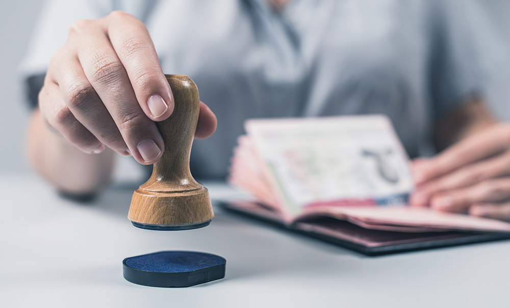 Immigration and passport control at the airport. woman border control officer puts a stamp in the US passport of american citizen. Concept